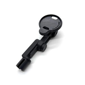 May include: A black, articulated device with a circular top and a slotted base. The top has a small hole and text. The device is made of a matte material and is designed to hold an object.