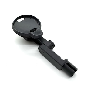 May include: A black, adjustable device with a circular top and a slotted end. The top has a small hole and text that reads "msafe 25w". The device has a hinged arm and a knob for adjustment. The object is set against a white background.