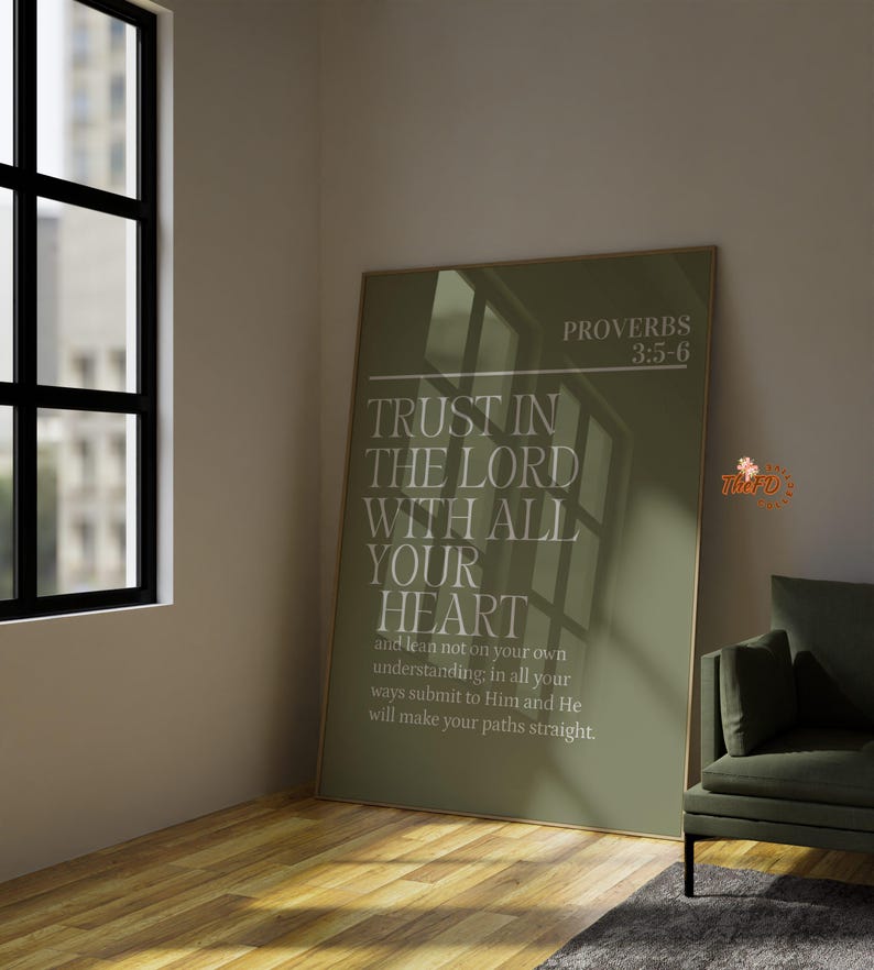 May include: A framed olive green poster with the text "TRUST IN THE LORD WITH ALL YOUR HEART" and "PROVERBS 3:5-6". The poster is displayed in a room with a window and a green armchair.