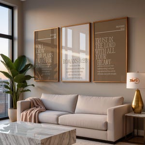 May include: Three framed wall art pieces with inspirational quotes hang above a light-colored sofa. The art features text from Jeremiah, Romans, and Proverbs. A large potted plant and a marble coffee table complete the living room setting.