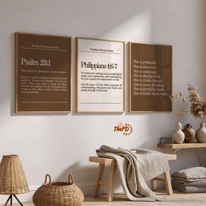 Puede incluir: Tres láminas rectangulares de pared en marcos de madera con texto blanco sobre fondo marrón. Las láminas muestran versículos bíblicos como Salmos 23:1 y Filipenses 4:6-7, junto a una lista de afirmaciones que comienza con She is protected.