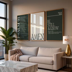 May include: Three framed wall art pieces with gold trim. The art features the text "PSALM 91", "AMEN", and "BE STILL & KNOW". The art is displayed above a beige sofa with a marble coffee table.