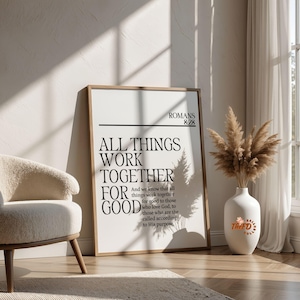 Op de afbeelding: Een rechthoekige ingelijste wandprint met de zwarte tekst Romans 8:28 en het citaat All things work together for good and we know that all things work together for good to those who love God, to those who are the called according to His purpose.