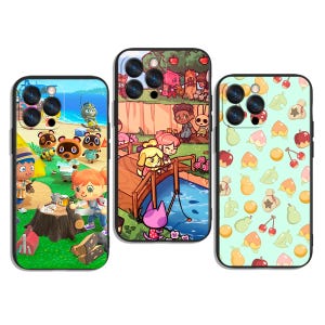 Puede incluir: Tres fundas para teléfono con diseños coloridos del videojuego Animal Crossing. Una funda muestra una escena de playa, otra presenta personajes en un puente y la tercera tiene un patrón de frutas y hojas.