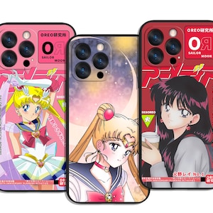 May include: Three phone cases with anime illustrations. The cases are pink, purple, and red, each depicting a different Sailor Moon character. The cases feature the text "OREO SAILOR MOON" and Japanese text. The cases have a glossy finish.