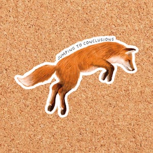 May include: A die-cut sticker featuring a realistic illustration of a leaping orange fox with a white-tipped tail. Above the fox, the text JUMPING TO CONCLUSIONS is printed in a simple black sans-serif font, following the curve of the fox's back.