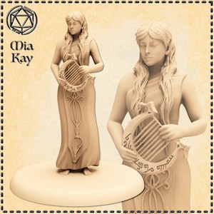 May include: A beige figurine of a woman holding a lyre. The woman is wearing a long dress and has long flowing hair. The lyre has an ornate design with text. The figurine is on a round base. The text "Mia Kay" is in the upper left corner.