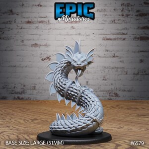 May include: A grey, unpainted miniature of a serpentine sea creature with a dragon-like head, sharp teeth, and a long, forked tongue. The creature features prominent dorsal fins and scales, mounted on a circular black base with a 51mm diameter.