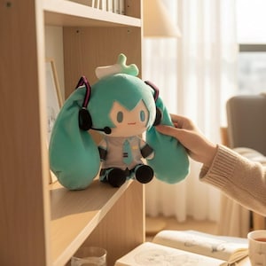 Op de afbeelding: Een pluche pop met turkoois haar en een bijpassende outfit, inclusief stropdas en koptelefoon. De pop heeft grote, expressieve ogen en staat op een houten plank. Het ontwerp van de pop is geïnspireerd op een populair anime-personage.