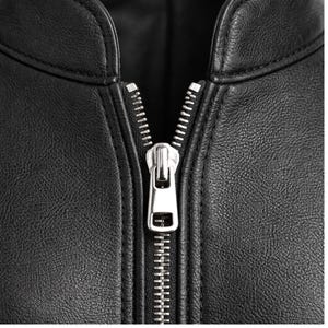 May include: Close-up of a black leather jacket with a silver zipper. The zipper is centered and fully closed, showcasing the jacket's design. The leather has a textured appearance.