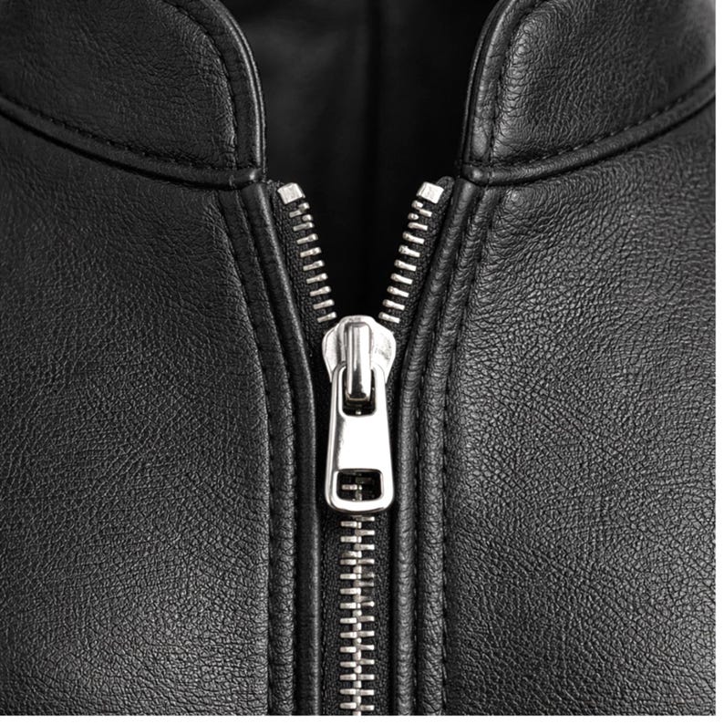 May include: Close-up of a black leather jacket with a silver zipper. The zipper is centered and fully closed, showcasing the jacket's design. The leather has a textured appearance.