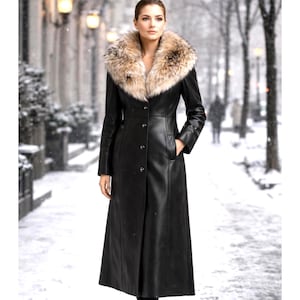 Woman walking in winter city wearing long black leather coat with fox fur collar, elegant luxury winter outerwear for women