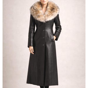 Elegant woman wearing a long black sheep leather coat with real fox fur collar, button front luxury winter coat shown in studio lighting