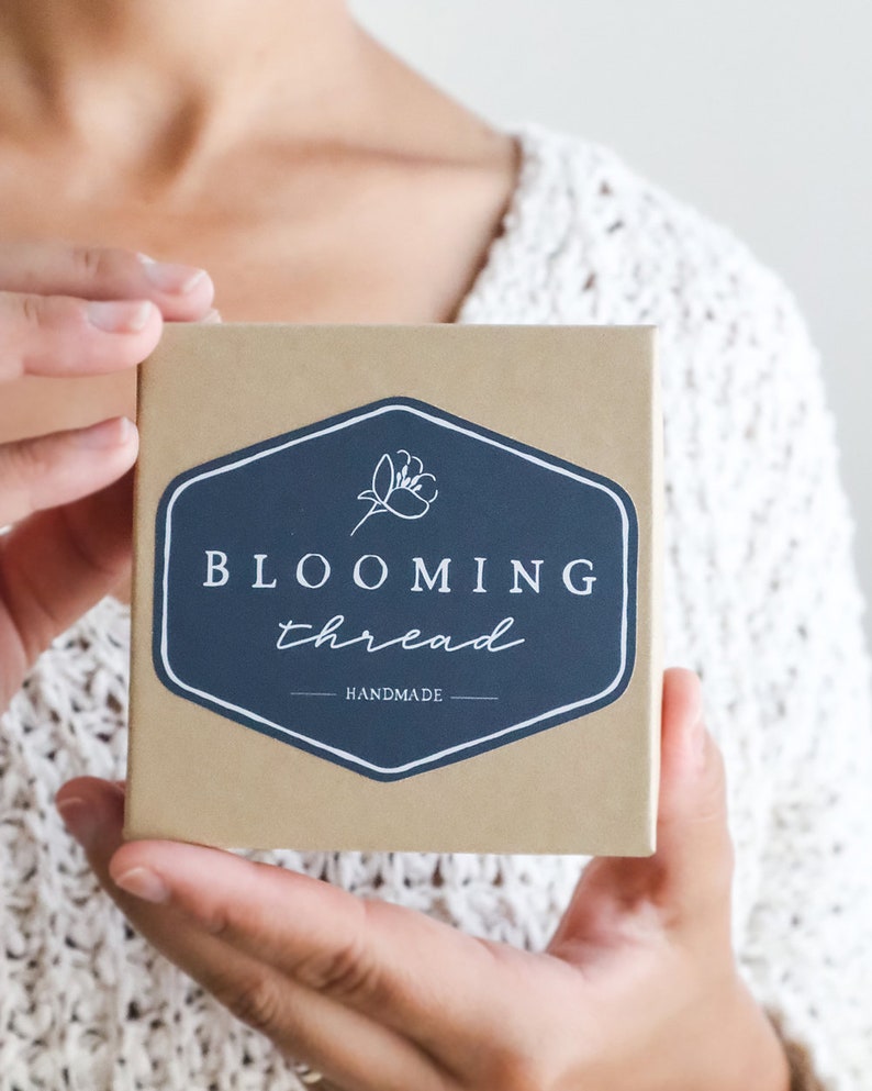 Peut inclure: Une bo&icirc;te brune avec un autocollant blanc qui dit "BLOOMING thread - HANDMADE" avec un graphique de fleur stylis&eacute;.