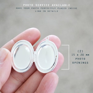 May include: A silver-toned oval locket with two interior compartments. The locket features two photo openings measuring 15 x 20 mm each. Text on the image reads: PHOTO SERVICE AVAILABLE, HAVE YOUR PHOTO PERFECTLY PLACED INSIDE, LINK IN DETAILS.