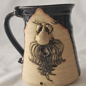 May include: A white ceramic mug with a black handle and the text "But First, Coffee" in a handwritten style. The mug is on a white surface. The mug is approximately 4 inches tall.
