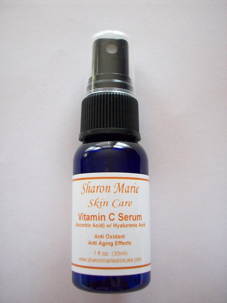 May include: A blue bottle with a white label that reads "Sharon Marie Skin Care Vitamin C Serum (Ascorbic Acid) w/ Hyaluronic Acid Anti Oxidant Anti Aging Effects 1 fl oz (30ml) www.sharonmarieskincare.com". The bottle has a black spray top.