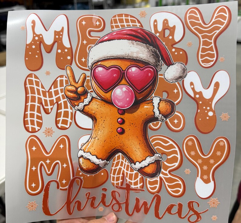 Op de afbeelding: Een feestelijk kerstontwerp met een peperkoekmannetje met een kerstmuts en hartvormige zonnebril, die een bel blaast. De woorden "MERRY CHRISTMAS" worden weergegeven in peperkoek-lettertype, met sneeuwvlokaccenten.