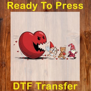 May include: A DTF transfer design featuring a large, angry red heart chasing a cupid, a teddy bear, and a gnome. The words "Ready To Press" and "DTF Transfer" are in yellow text.