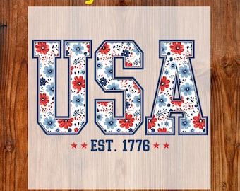 May include: A DTF transfer featuring the word "USA" in a collegiate font, filled with a floral pattern of red and blue flowers on a white background. The text "EST. 1776" is below the letters, with stars on either side. The words "Ready To Press" and "DTF Transfer" are also present.