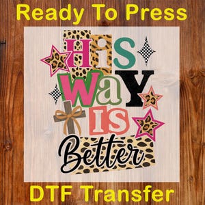 Op de afbeelding: Een DTF-transferontwerp met de woorden "HIS WAY IS BETTER" in verschillende lettertypen en kleuren. Het ontwerp bevat een kruis, sterren en luipaardprint accenten. De woorden "Ready To Press" en "DTF Transfer" zijn ook opgenomen.