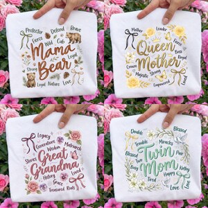 May include: Four white t-shirts with different designs. One says "Mama Bear" with a bear illustration. Another says "Queen Mother" with a crown and floral accents. The third says "Great Grandma" with floral elements. The last says "Twin Mom".