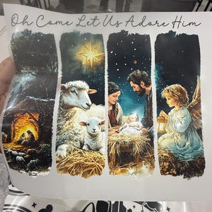 Peut inclure: Image &agrave; th&egrave;me religieux avec le texte &laquo; Oh Come Let Us Adore Him &raquo;. L'image repr&eacute;sente des sc&egrave;nes de la Nativit&eacute;, dont une &eacute;table, des moutons, la Sainte Famille et un ange. L'&oelig;uvre pr&eacute;sente un ciel &eacute;toil&eacute; et des couleurs chaudes.