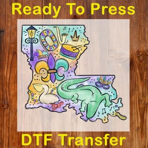 May include: A colorful DTF transfer featuring the outline of Louisiana, filled with Mardi Gras-themed illustrations. Includes a fleur-de-lis, alligator, musical instruments, and the words "Ready To Press" and "DTF Transfer".