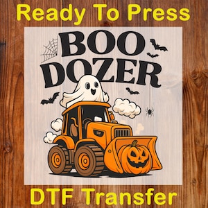 May include: A Halloween-themed graphic featuring an orange bulldozer with a jack-o'-lantern blade and a ghost driver. The text "BOO DOZER" is above the bulldozer, with "Ready To Press" and "DTF Transfer" at the top and bottom.
