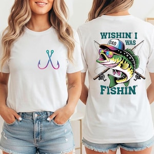 May include: White t-shirt with a colorful fish hook design on the front. The back of the shirt features a graphic of a fish wearing sunglasses and a hat, with the text "Wishin' I Was Fishin'".