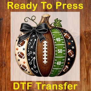 May include: A pumpkin-shaped graphic with a black bow on top. The design features segments with football patterns, a green field with yard lines, white play diagrams, and small orange stars. The text Ready To Press DTF Transfer is visible.