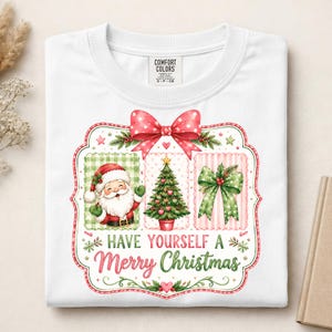 May include: A white t-shirt featuring a graphic print of a red polka-dot bow above three panels containing a Santa Claus, a Christmas tree, and a green bow. The text "HAVE YOURSELF A Merry Christmas" is printed in red and green below the panels.