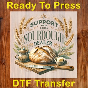 May include: DTF transfer featuring a sourdough bread design. The image includes a loaf of bread, a knife, butter, and the text "Support Your Local Sourdough Dealer." The words "Ready To Press" and "DTF Transfer" are also visible.