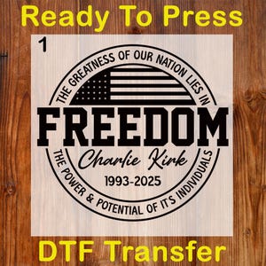 May include: A DTF transfer with the text "Ready To Press" in yellow at the top and "DTF Transfer" at the bottom. The design features a circular emblem with the word "FREEDOM" and the text "The Greatness of Our Nation Lies In" and "The Power & Potential of Its Individuals".