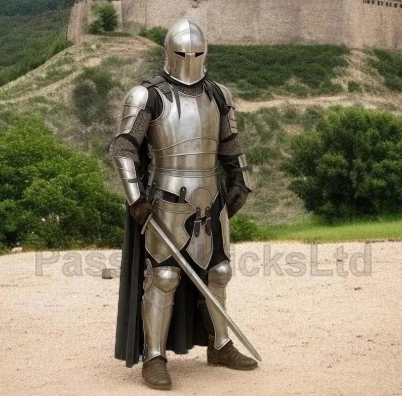 Puede incluir: Una armadura medieval completa, que incluye un casco, peto y protectores de piernas. La armadura plateada se usa con una capa y guantes negros. Se sostiene una espada. El fondo presenta un castillo de piedra y follaje verde.