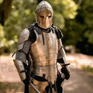 Puede incluir: Una armadura medieval completa, que incluye un casco, peto y protectores de brazos y piernas. La armadura est&aacute; hecha de metal pulido y presenta detalles de cota de malla. El casco tiene una visera y un dise&ntilde;o de cruz. El fondo est&aacute; borroso, con &aacute;rboles verdes.