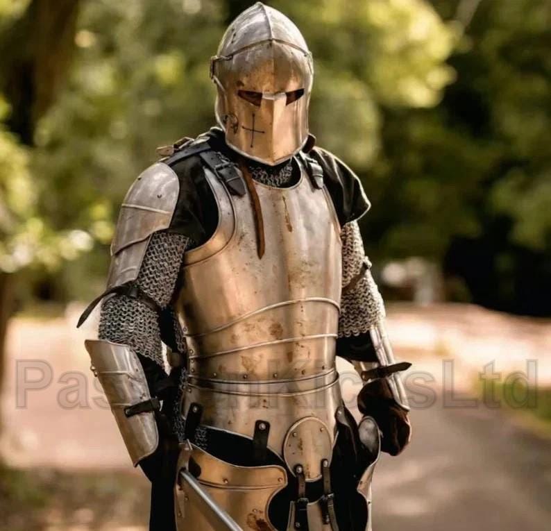 Puede incluir: Una armadura medieval completa, que incluye un casco, peto y protectores de brazos y piernas. La armadura est&aacute; hecha de metal pulido y presenta detalles de cota de malla. El casco tiene una visera y un dise&ntilde;o de cruz. El fondo est&aacute; borroso, con &aacute;rboles verdes.