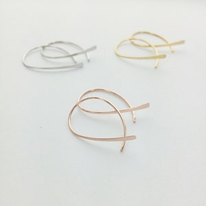 Può includere: Tre paia di orecchini a cerchio in diverse finiture: argento, oro e oro rosa. Gli orecchini sono semplici e delicati, con un design a filo sottile.