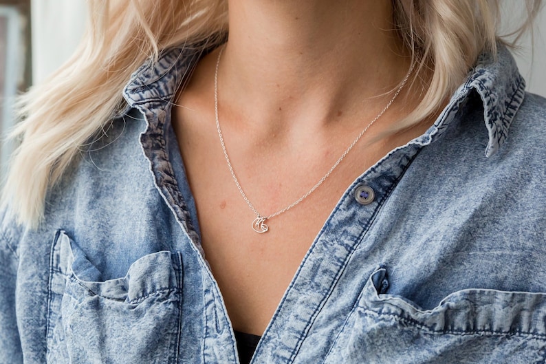 May include: A silver chain necklace with a small, delicate sloth pendant.