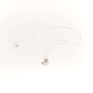 May include: A silver chain necklace with a small silver sloth pendant.