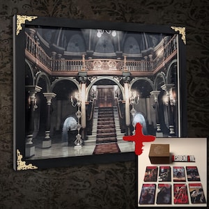 Puede incluir: Impresión enmarcada de un interior gótico con una escalera y detalles ornamentados. Incluye una pequeña caja de madera y varias portadas de juegos de Resident Evil. El marco es negro con detalles dorados en las esquinas.