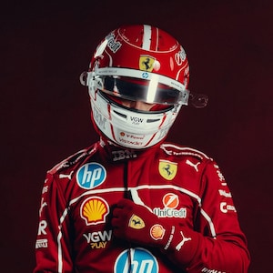 May include: A red racing suit and helmet with white accents. The helmet features the Ferrari logo and sponsor logos. The suit has multiple sponsor logos, including HP, Shell, and UniCredit. The gloves are red with the Ferrari logo.