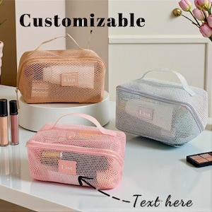 May include: Three mesh cosmetic bags in peach, pink, and light blue, each with a handle and a "Lisa" label. The bags are filled with makeup products. The word "Customizable" is at the top of the image, and "Text here" is at the bottom.