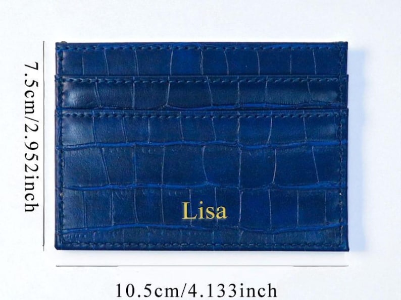 Puede incluir: Tarjetero azul con textura de cocodrilo, de 10,5 cm por 7,5 cm. El nombre "Lisa" est&aacute; impreso en dorado en la parte delantera. Cuenta con m&uacute;ltiples ranuras para tarjetas. Dimensiones aproximadas: 4,133 pulgadas por 2,952 pulgadas.