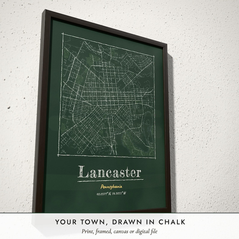 Three-quarter view of the framed Chalkboard City Map poster on a white plaster wall