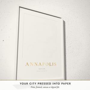 Three-quarter view of the framed Embossed City Map poster on a white plaster wall