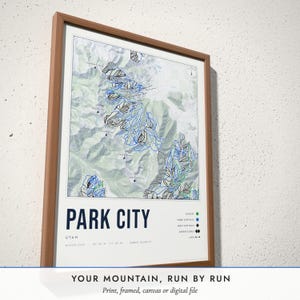 Three-quarter view of the framed Ski Resort Map poster on a white plaster wall