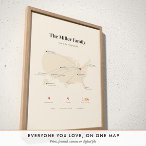 Three-quarter view of the framed Family Near & Far Map poster on a white plaster wall