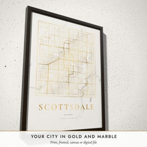 Three-quarter view of the framed Marble & Gold City Map poster on a white plaster wall