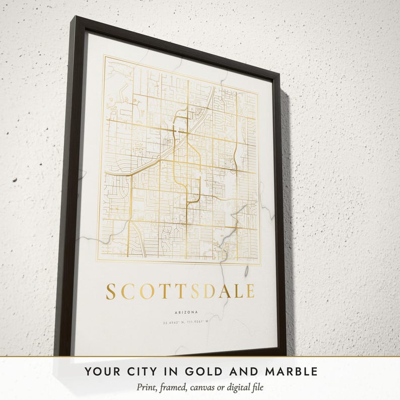 Three-quarter view of the framed Marble & Gold City Map poster on a white plaster wall